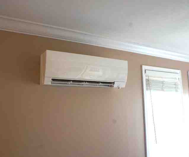 modern ductless mini-split unit mounted on a wall in a living room - home heating and cooling modern ductless mini-split unit mounted on a wall in a living room - home heating and cooling