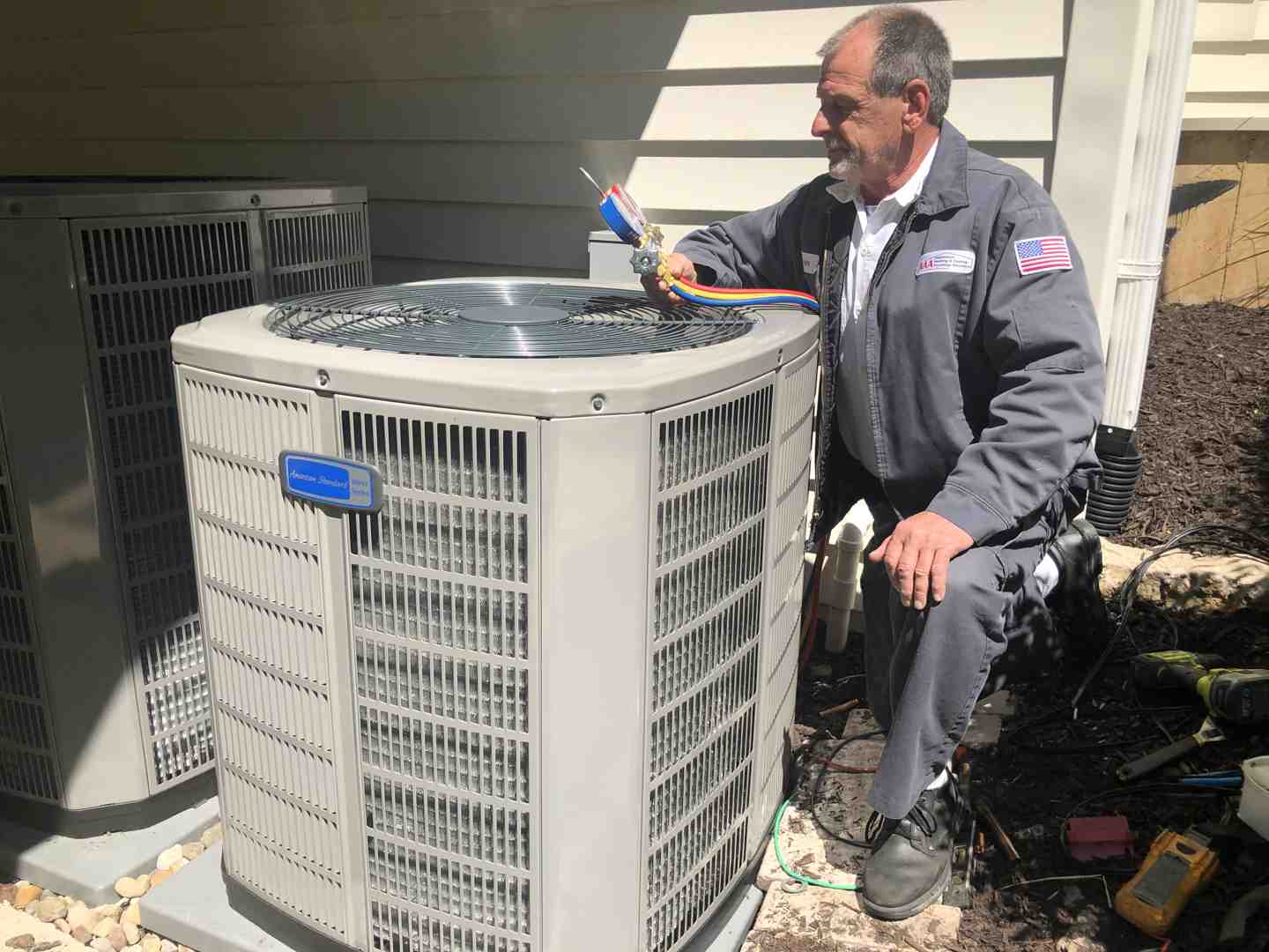 Technician performing maintenance on an American Standard unit - American Standard Heating & Cooling Technician performing maintenance on an American Standard unit - American Standard Heating & Cooling