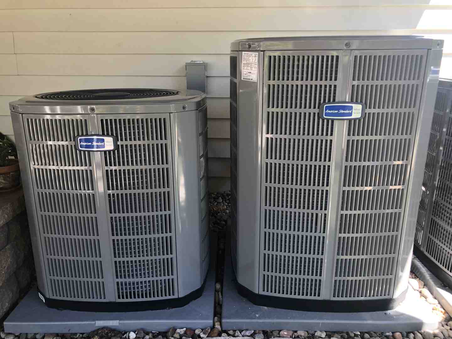 Homeowner safely cleaning outdoor condenser coils with garden hose - ac unit maintenance Homeowner safely cleaning outdoor condenser coils with garden hose - ac unit maintenance