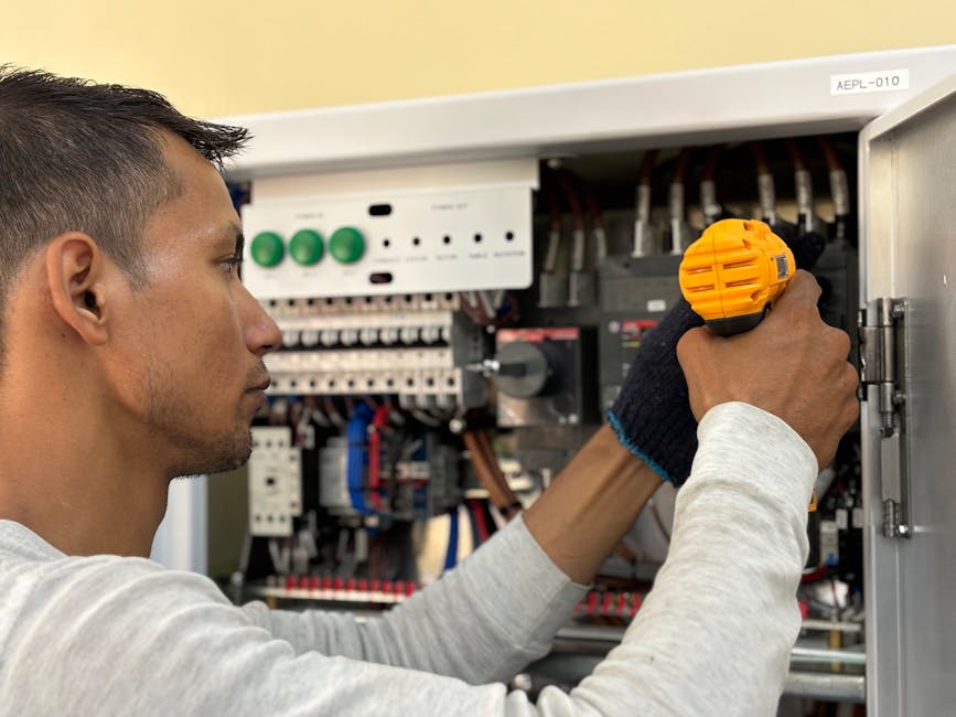 electrician working on electrical panel - electrician cost per hour electrician working on electrical panel - electrician cost per hour